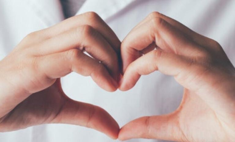 Foto huisarts die hartje maakt met zijn handen